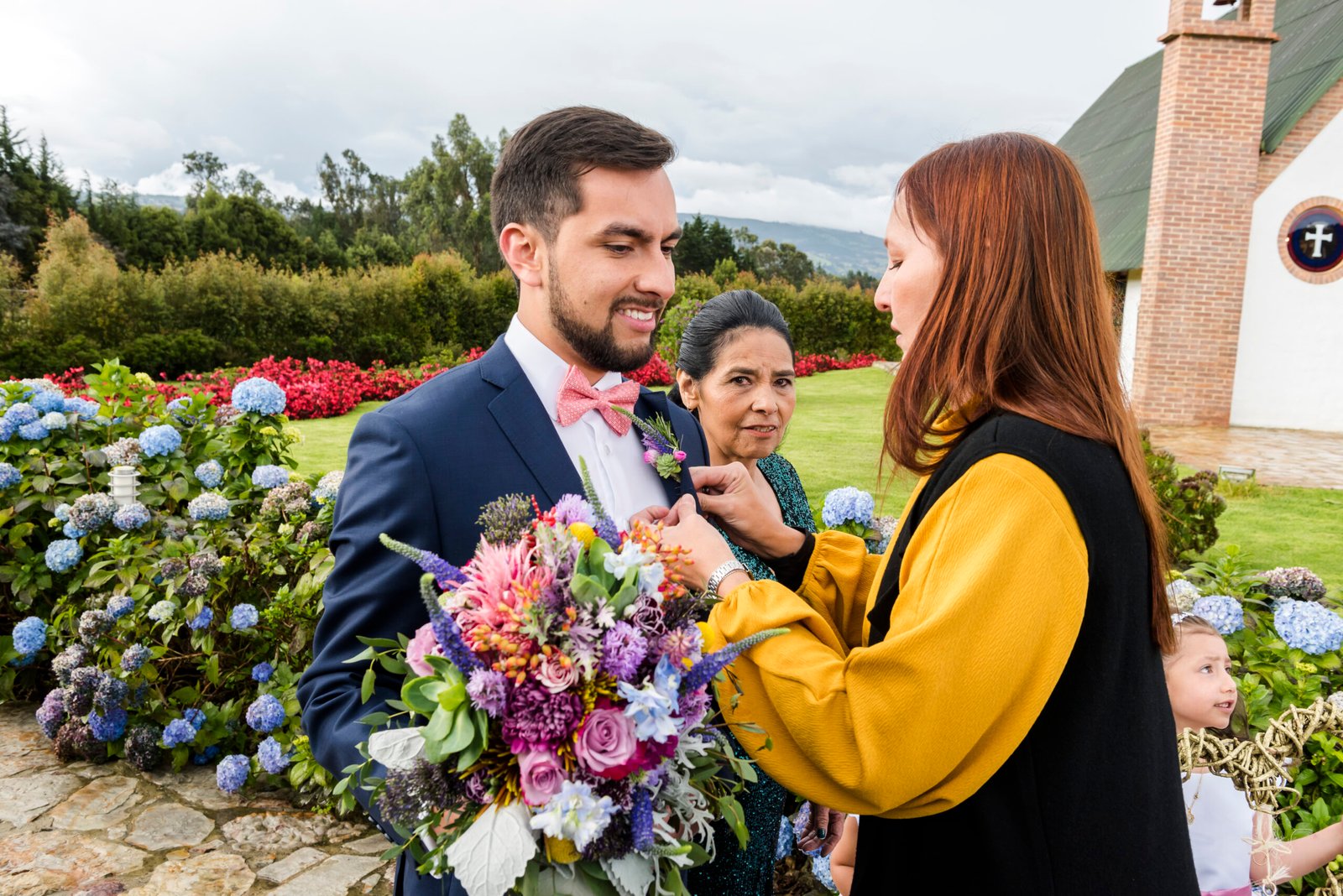 Sandra, organizadora de bodas, revisando los detalles del vestido del novio floral y el protocolo.